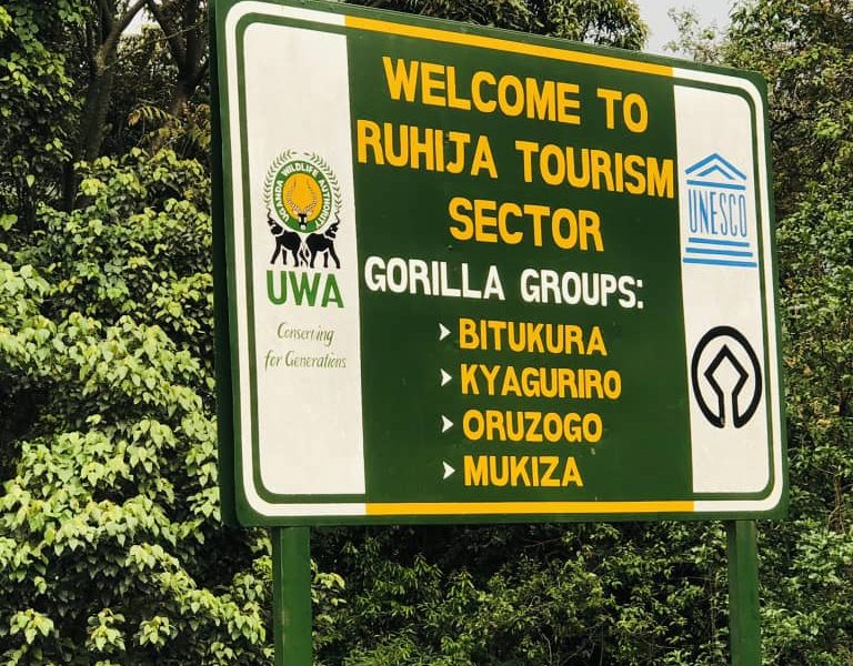 Bwindi Impenetrable National Park entrance gate with visitors paying park fees