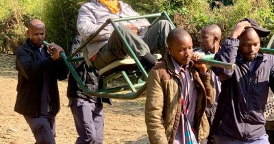 Old man Being carried to go and Track Gorillas of Bwindi In Uganda