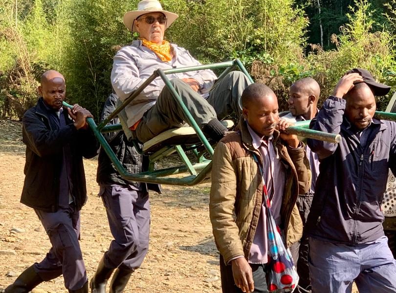 Old man Being carried to go and Track Gorillas of Bwindi In Uganda