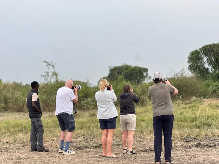 Tourists enjoying the Best Uganda safari experience with mountain and savannah views