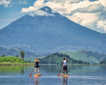 Tourists on A canoe Trip on Lake Mutanda while Enjoying Spectacular Views of Mgahinga in the background