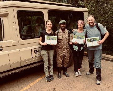 A Family of 3 Pausing with their Gorilla Trekking Certificates After their Safari in Bwindi South Western Uganda.